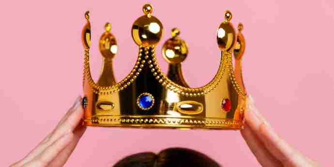 Woman holding a replica crown over her head as if to lower it to her own head - Embracing Self-Care and Self-Love: Unleash Your Inner Queen